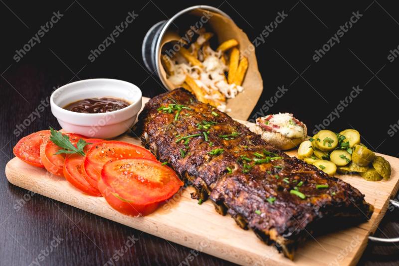 Delicious grilled ribs served with fresh vegetables and sides in a cozy restaurant setting
